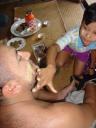 La bambina pone la crema cosmetica sul viso di Manu